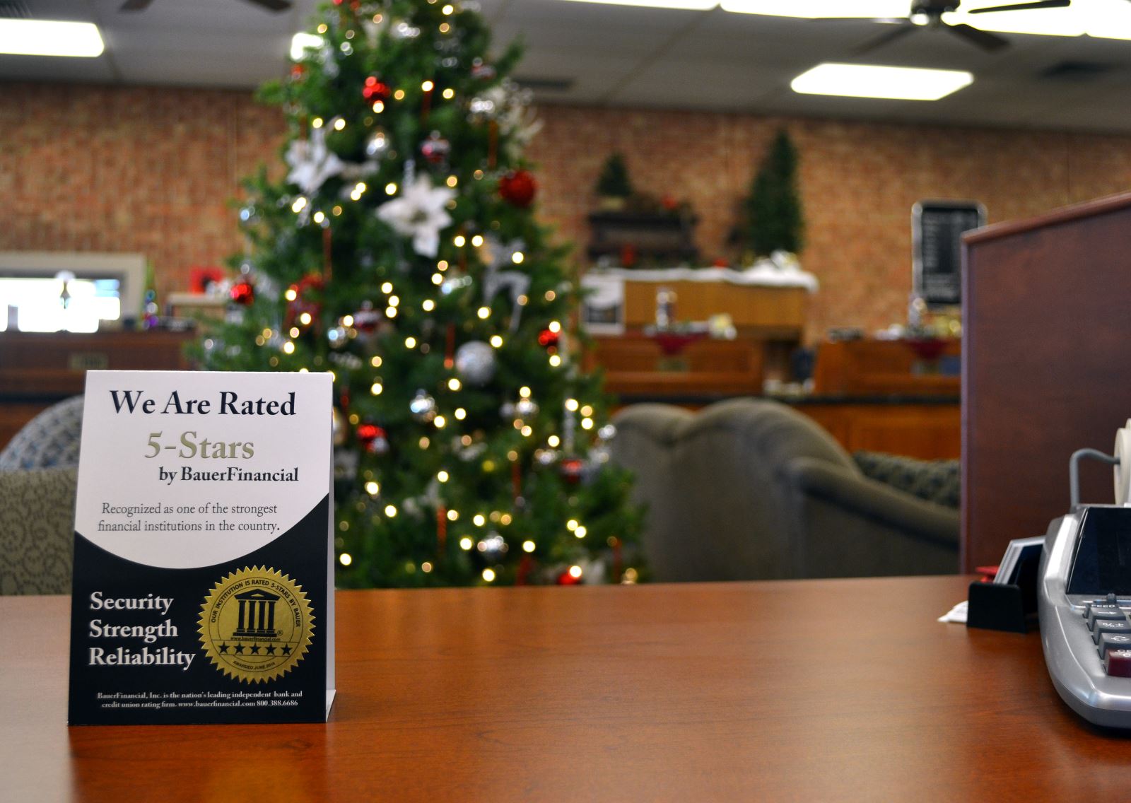 Deskholder announcing that we are a 5-star bank from Bauer Financial with Christmas tree in background